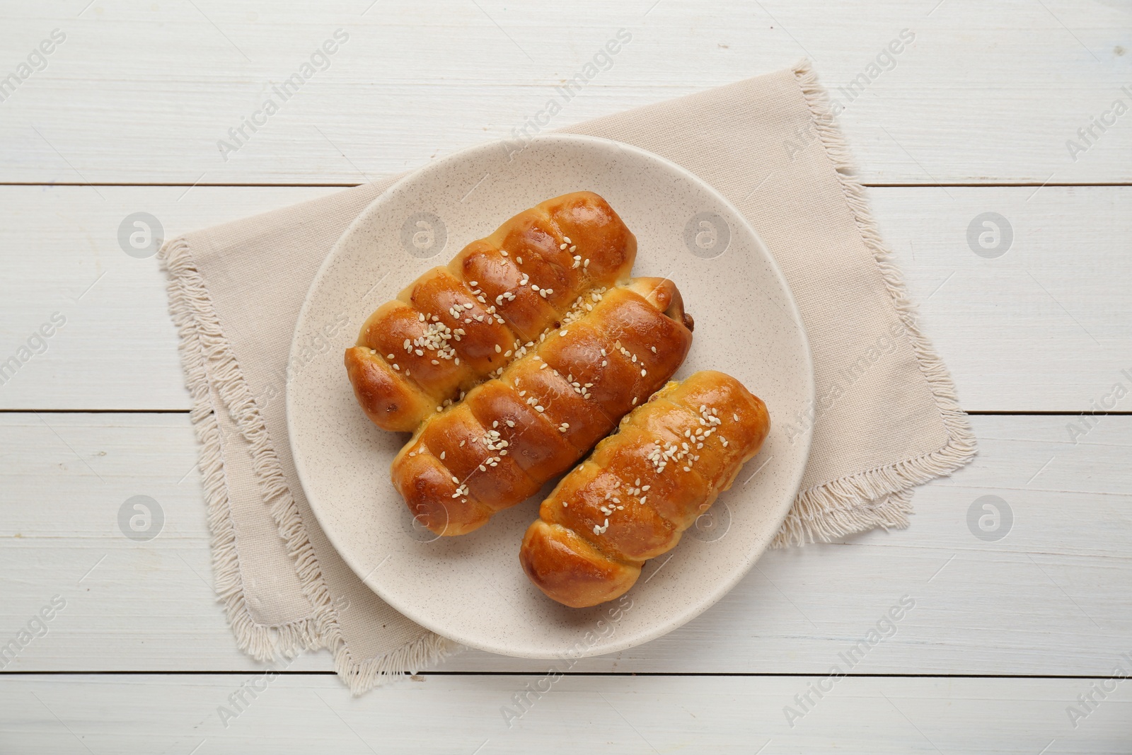 Photo of Delicious sausage rolls on white wooden table, top view