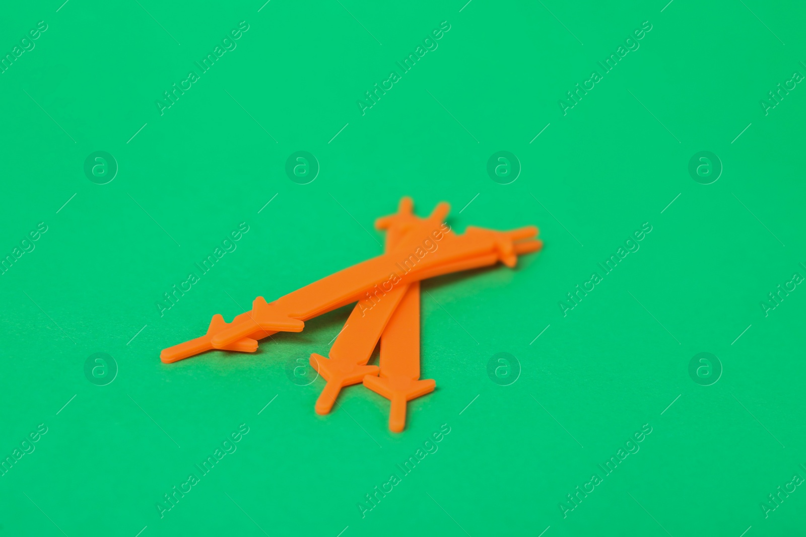 Photo of Orange silicone shoe laces on green background