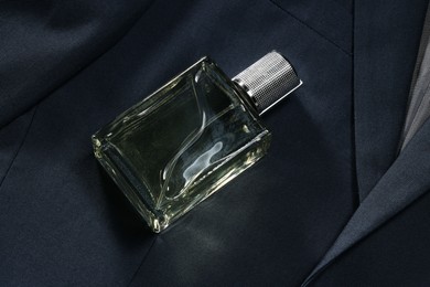 Photo of Luxury men's perfume in bottle on grey jacket, above view