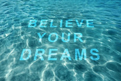 Image of Motivational quote Believe Your Dreams, view on text through ocean water