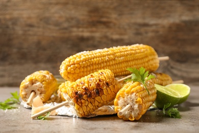 Delicious grilled corn cobs on grey table