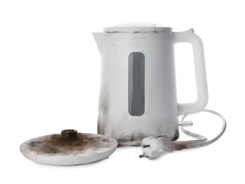 Burnt electric kettle with base and plug on white background