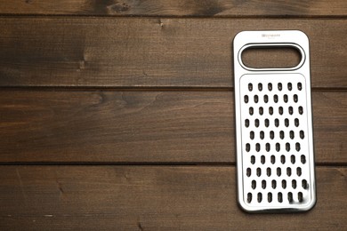 Photo of Modern grater on wooden table, top view. Space for text