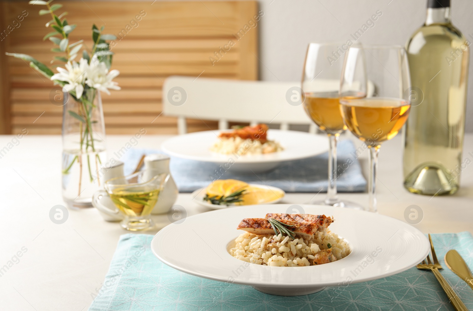 Photo of Delicious chicken risotto with rosemary served on table