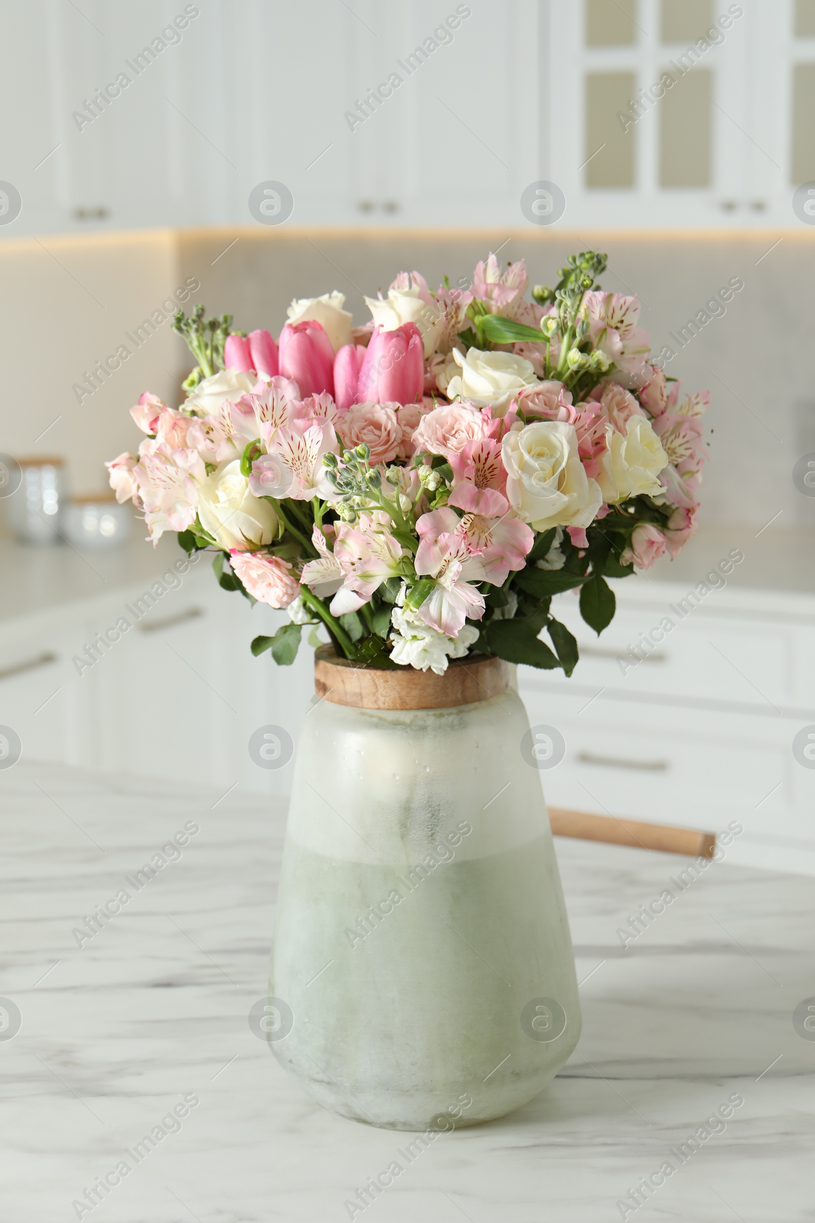 Photo of Beautiful bouquet of fresh flowers in vase on table indoors