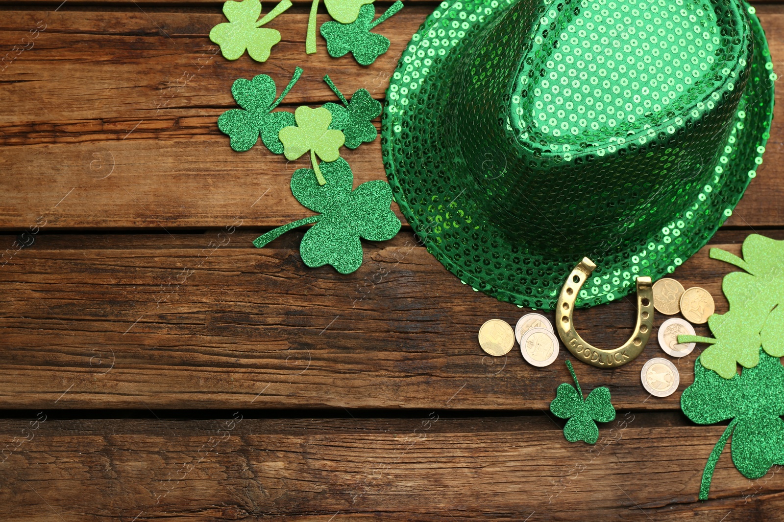 Photo of Flat lay composition with leprechaun hat on wooden table, space for text. St Patrick's Day celebration