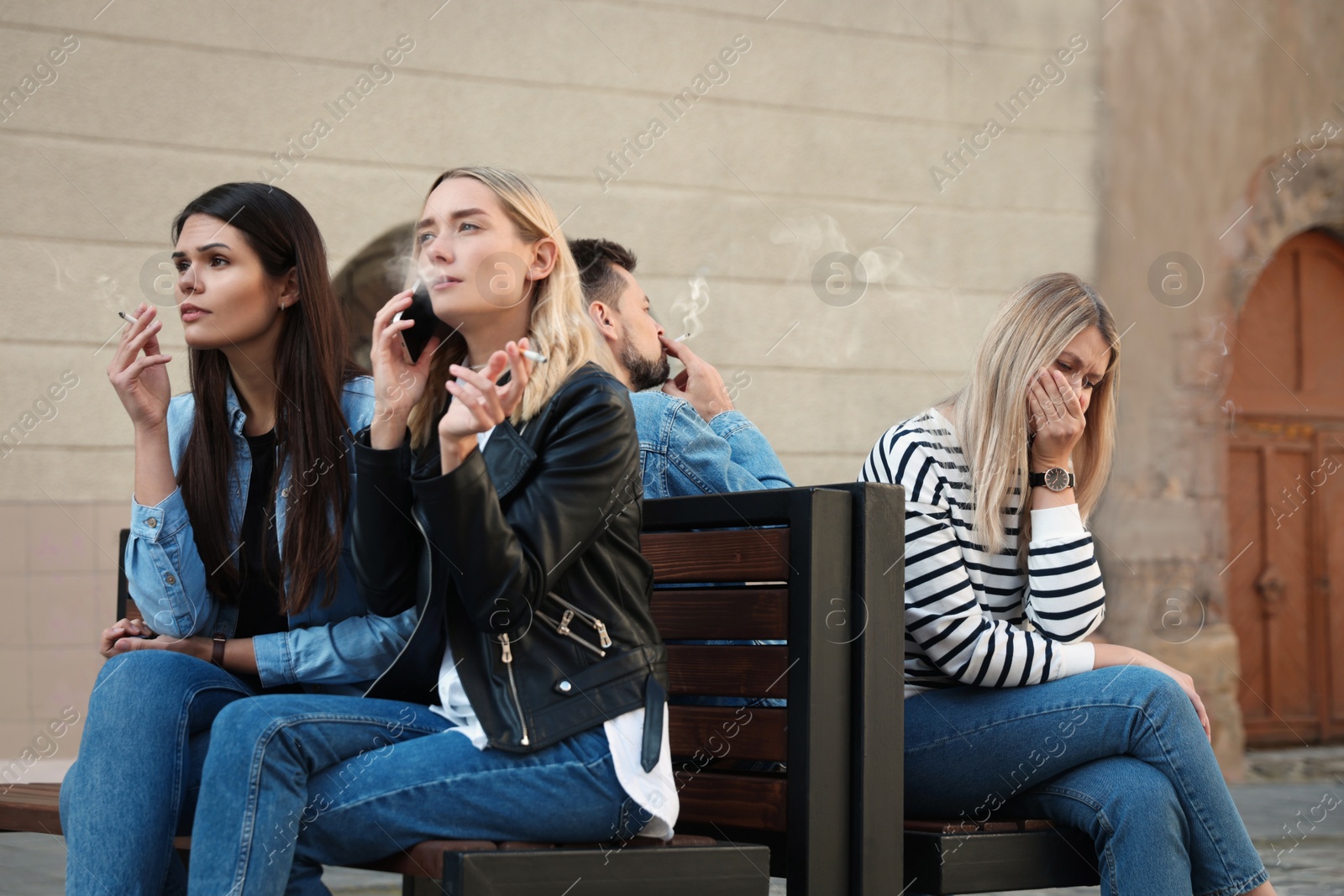 Photo of People smoking cigarettes at public place outdoors