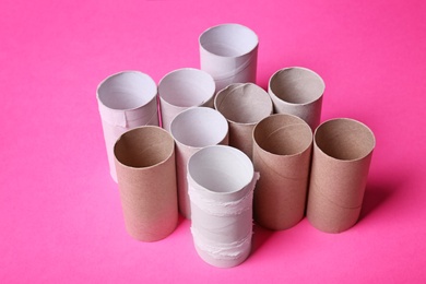 Photo of Empty toilet paper rolls on color background