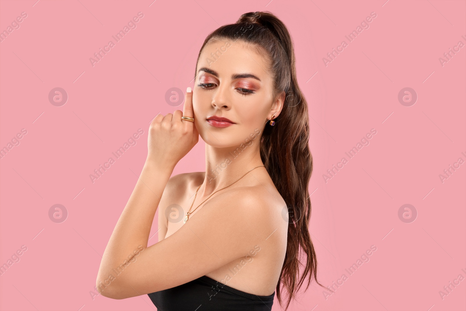 Photo of Beautiful woman with elegant jewelry on pink background