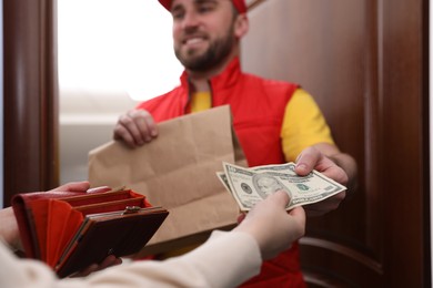 Photo of Deliveryman receiving tips from woman indoors, closeup