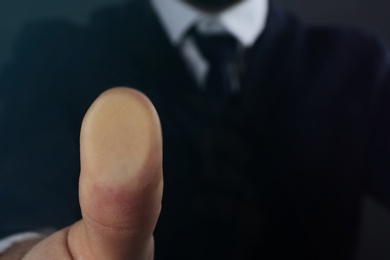 Businessman pressing control glass of biometric fingerprint scanner, closeup. Space for text