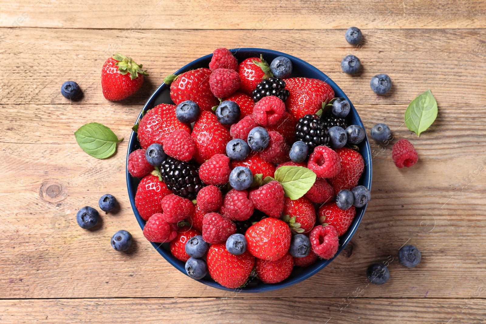 Photo of Different fresh ripe berries on wooden table, flat lay