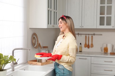 Photo of Woman singing while washing dishes in kitchen