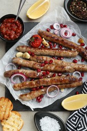 Photo of Tasty grilled sausages served on light table, flat lay