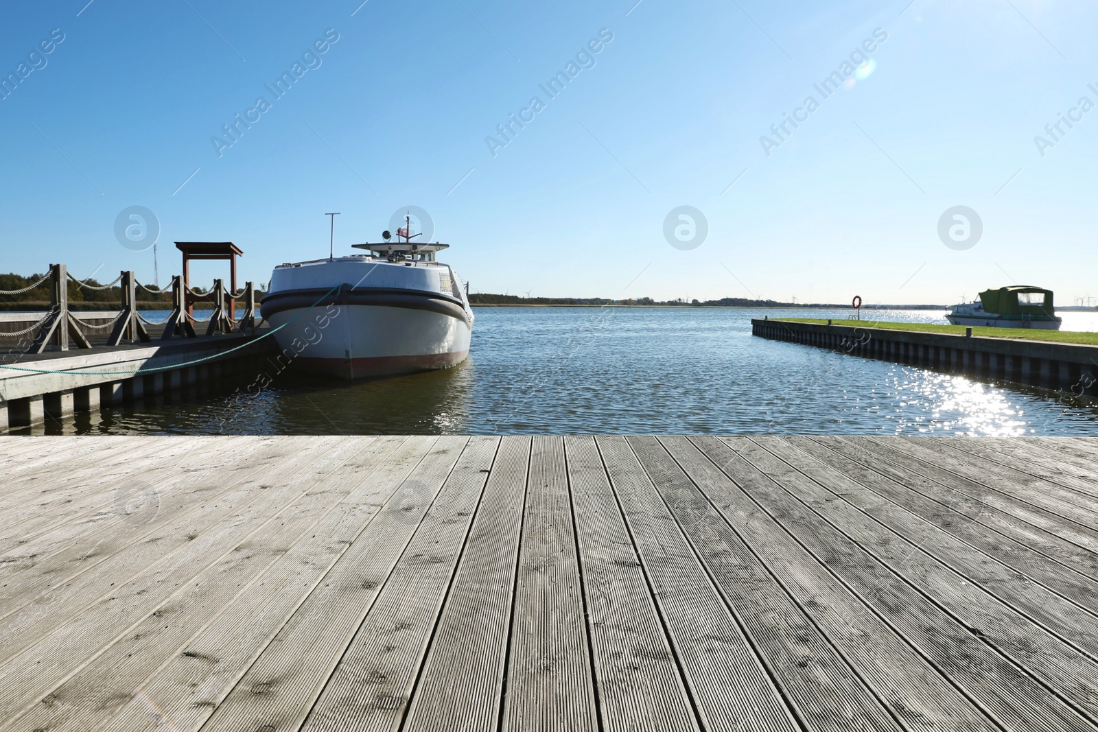 Photo of Beautiful view of wooden terrace and boat near river on sunny day