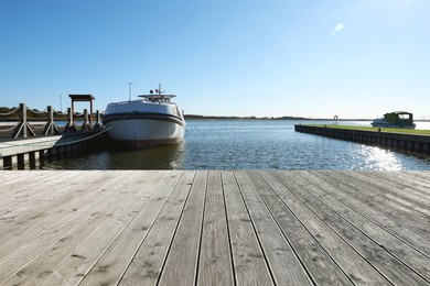 Photo of Beautiful view of wooden terrace and boat near river on sunny day