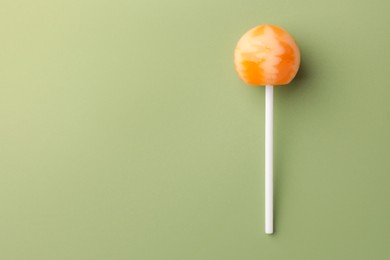 Photo of Tasty lollipop on green background, top view. Space for text