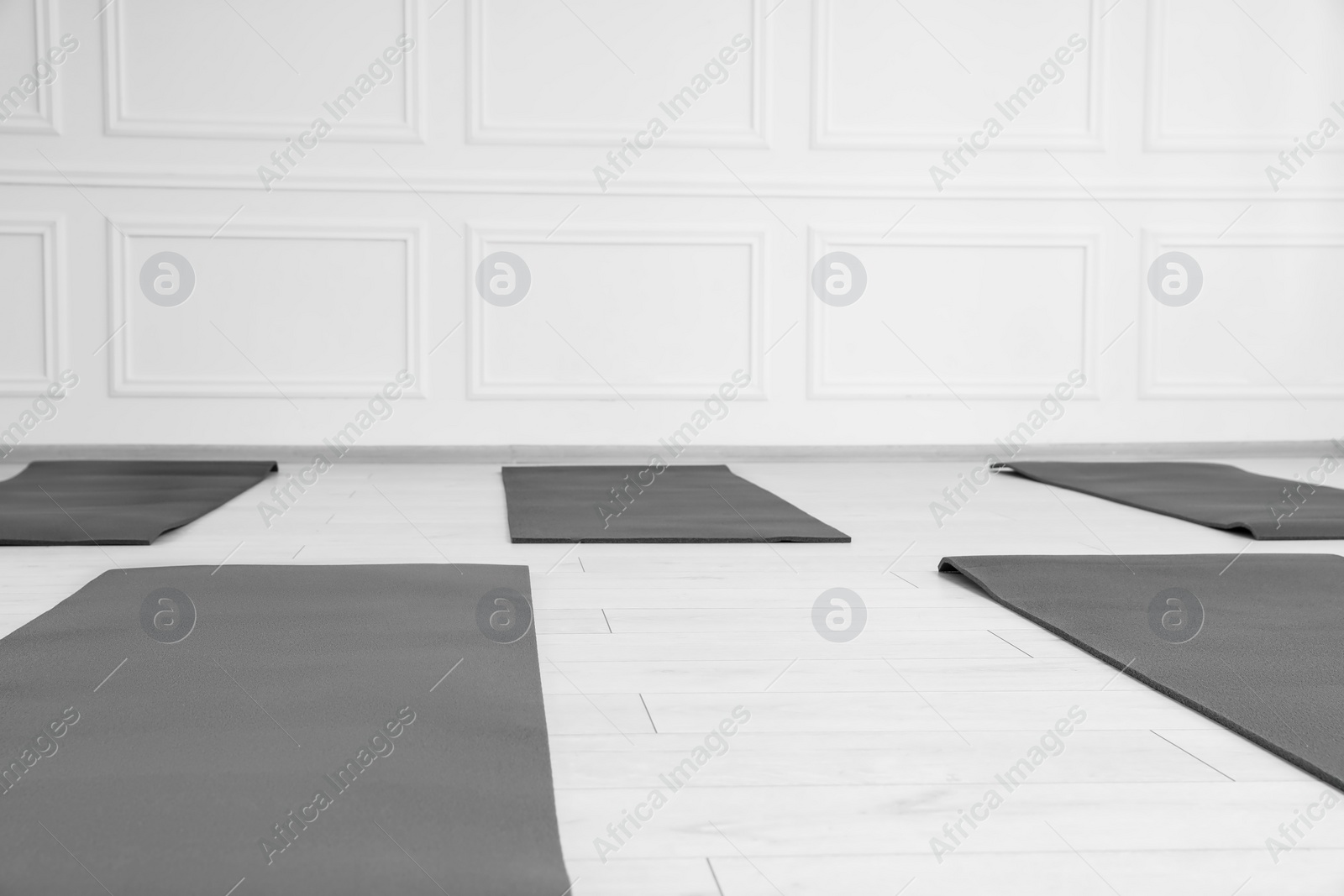 Photo of Spacious yoga studio with exercise mats. Space for text