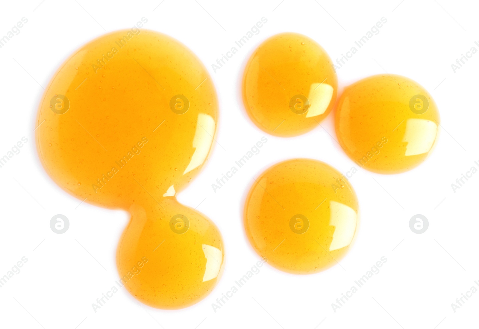 Photo of Drops of delicious honey on white background, top view