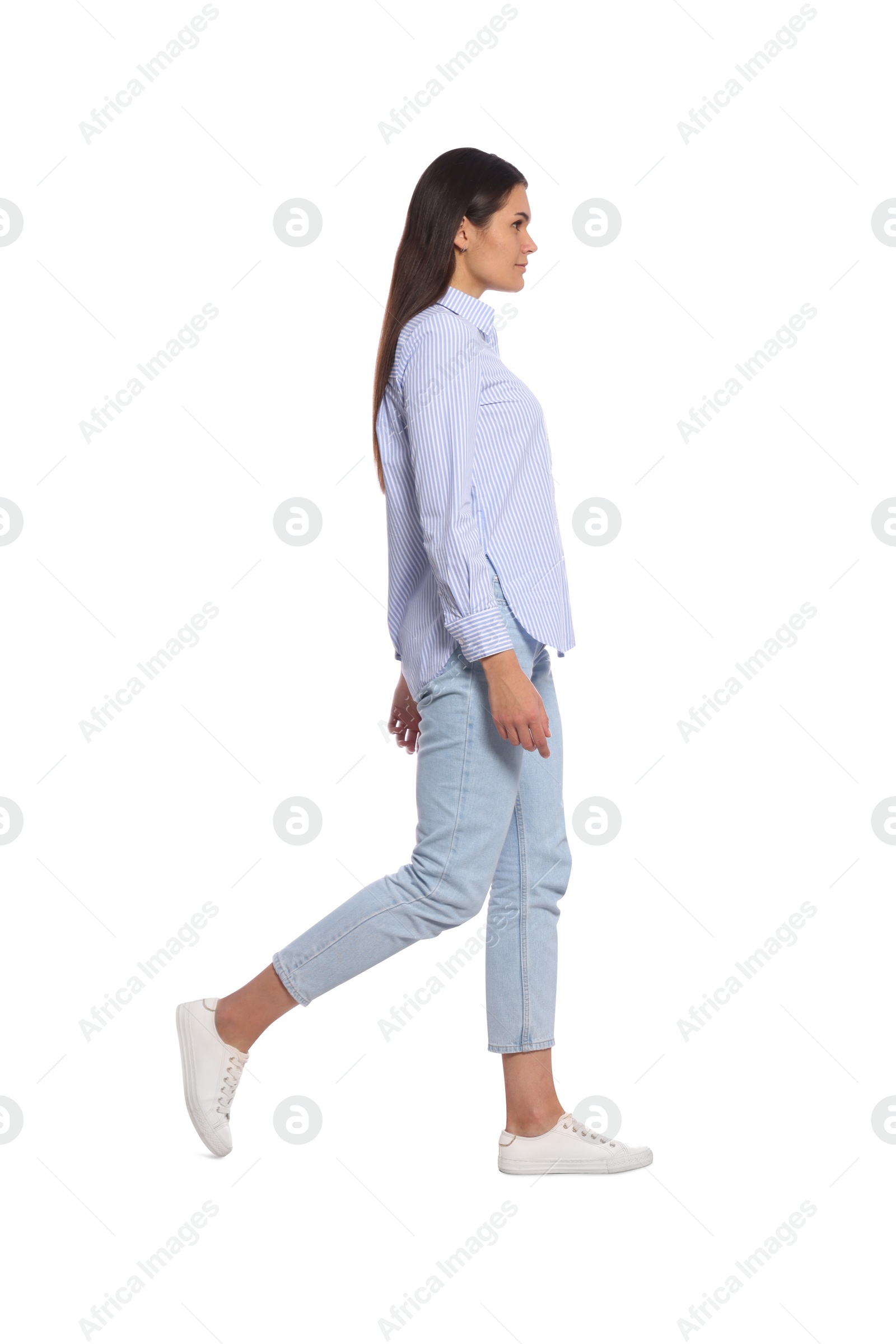 Photo of Young woman in stylish outfit walking on white background