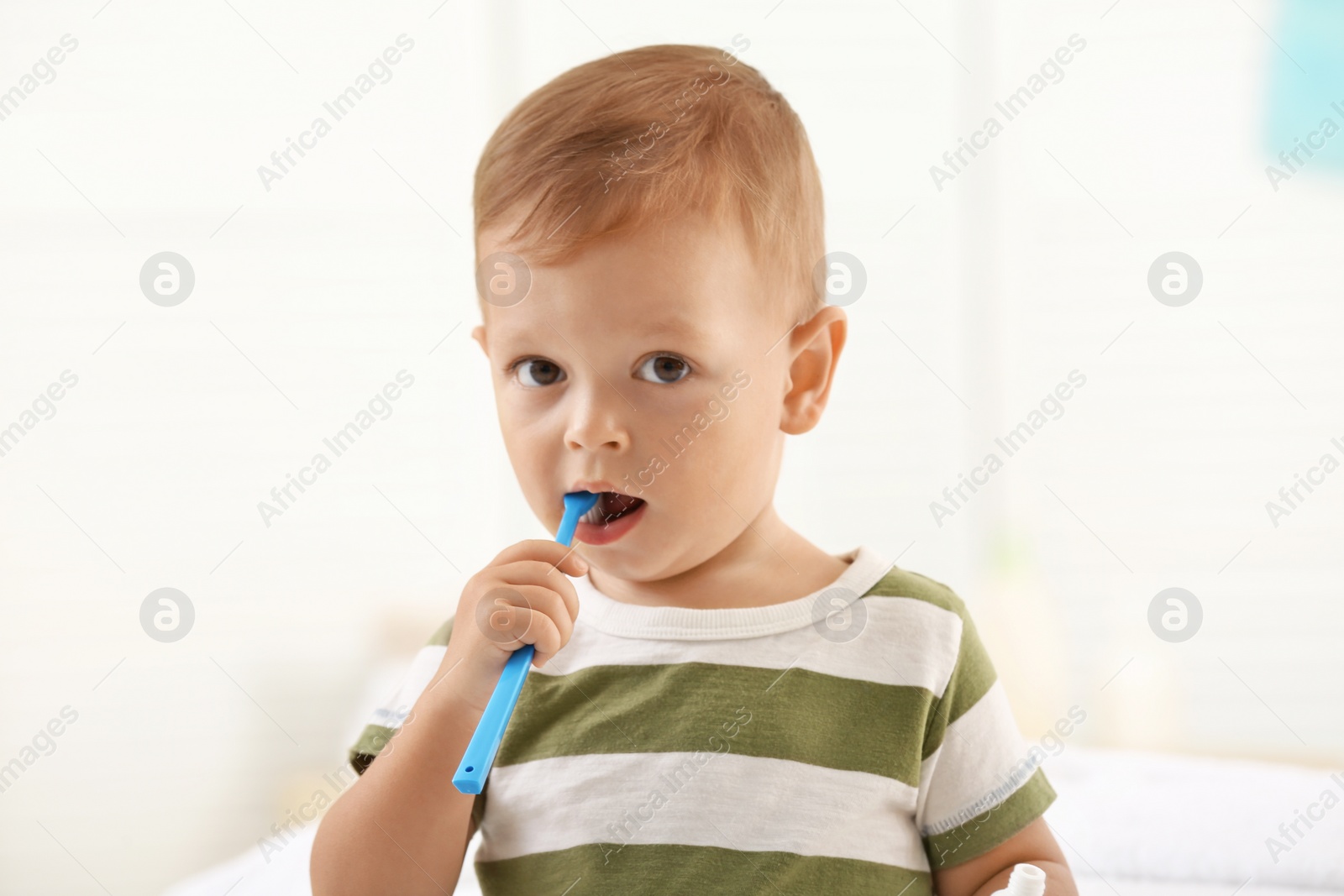 Photo of Cute little boy with toothbrush on blurred background