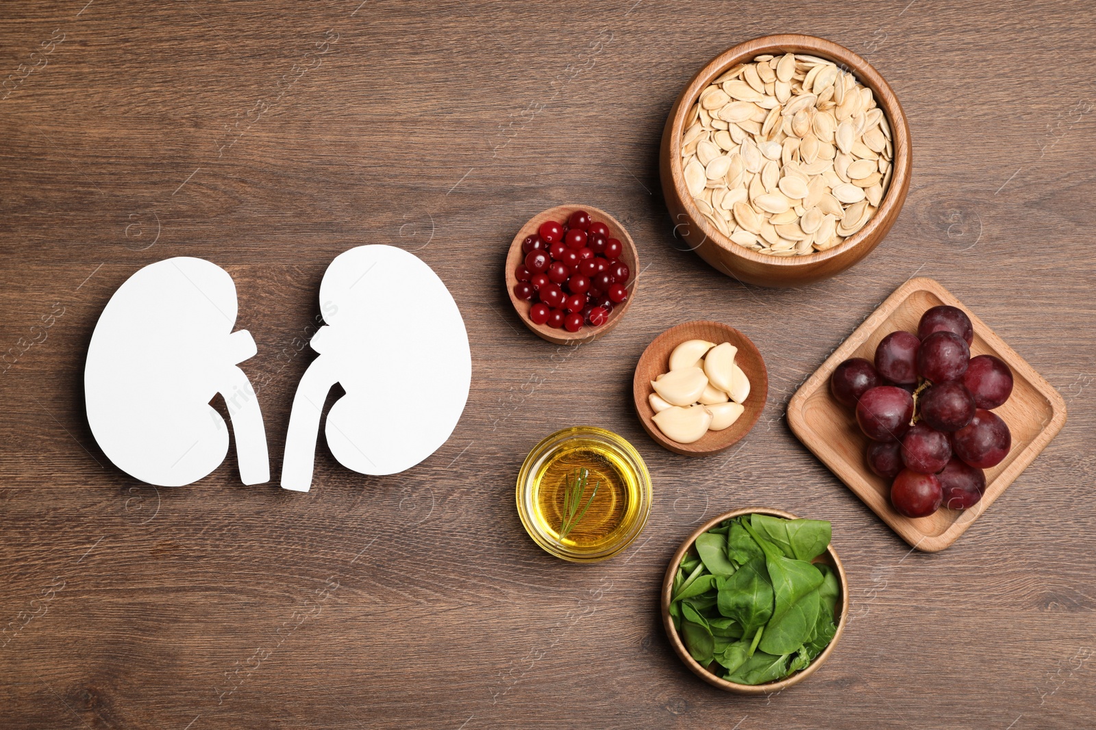 Photo of Flat lay composition with paper cutout of kidneys and different products on wooden table