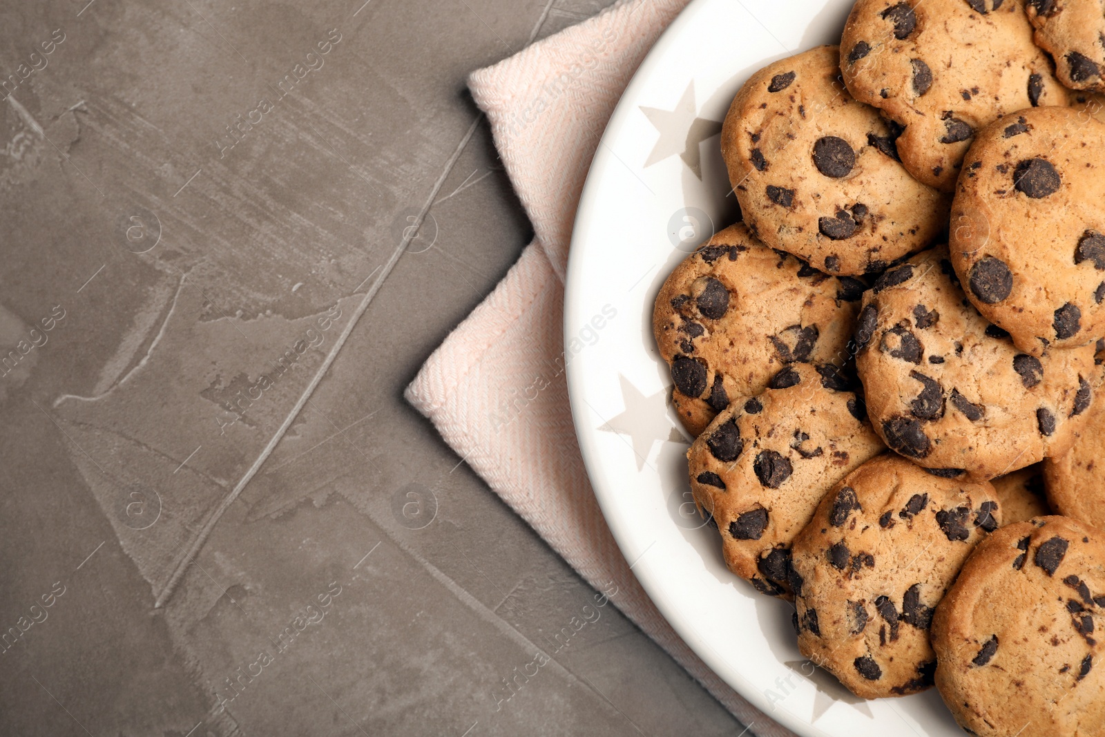 Photo of Plate with chocolate chip cookies and space for text on grey background, top view