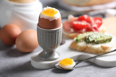 Photo of Tasty boiled chicken egg served for breakfast on light grey table