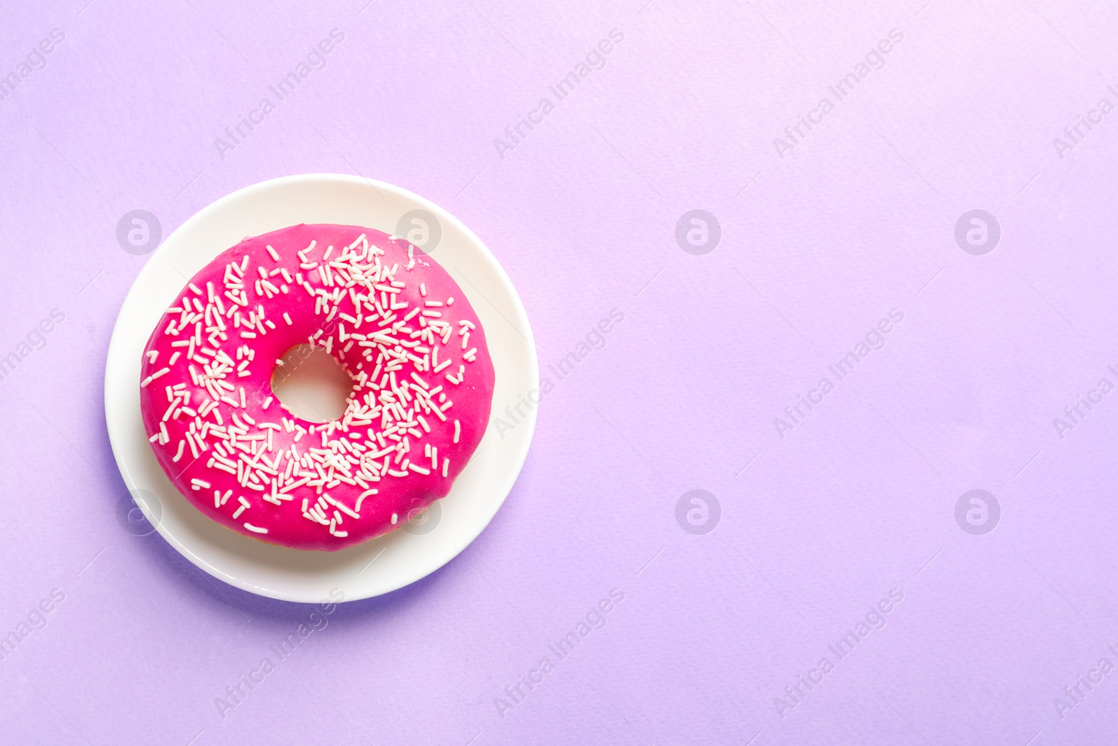 Photo of Plate with delicious doughnut on color background, top view