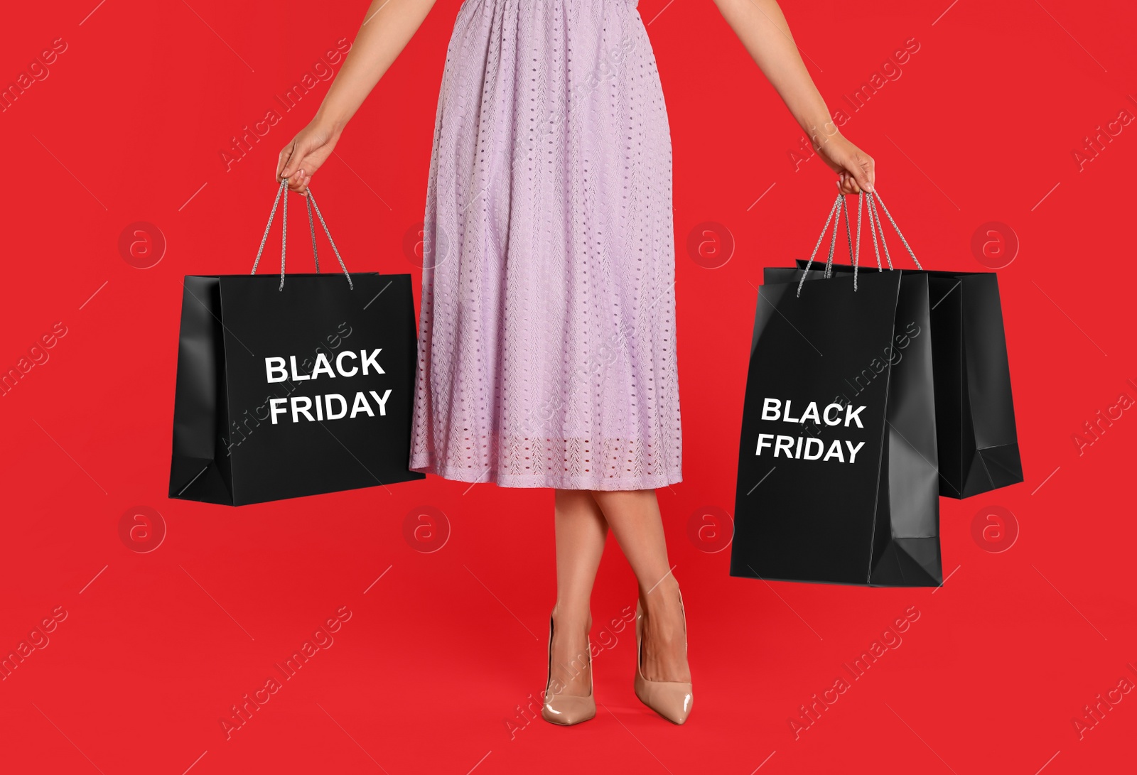 Photo of Woman with shopping bags on red background, closeup. Black Friday