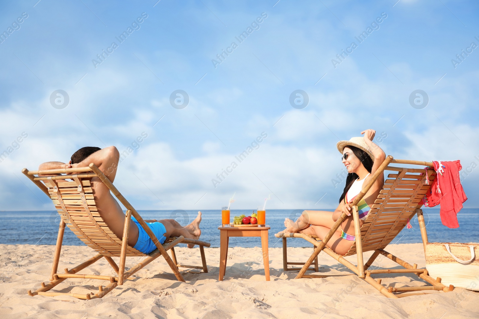 Photo of Couple resting on sunny beach at resort