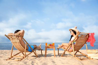 Couple resting on sunny beach at resort