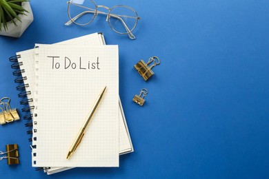 Flat lay composition with unfilled To Do list and glasses on blue background, space for text