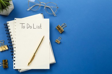 Photo of Flat lay composition with unfilled To Do list and glasses on blue background, space for text