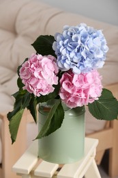 Photo of Beautiful hortensia flowers in can on stand indoors