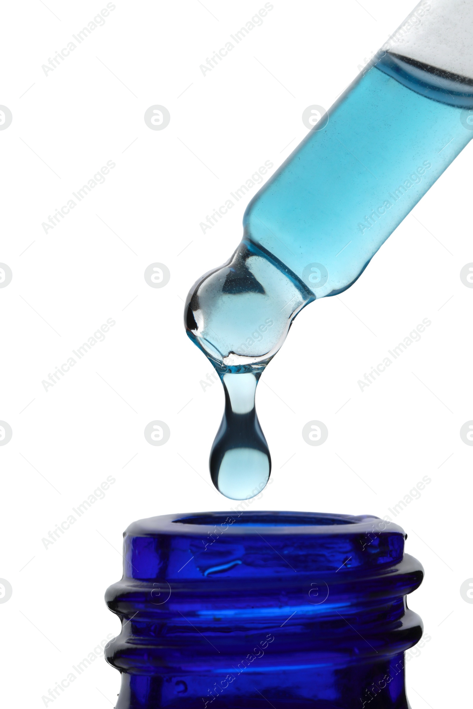 Photo of Dripping light blue facial serum from pipette into glass bottle on white background, closeup