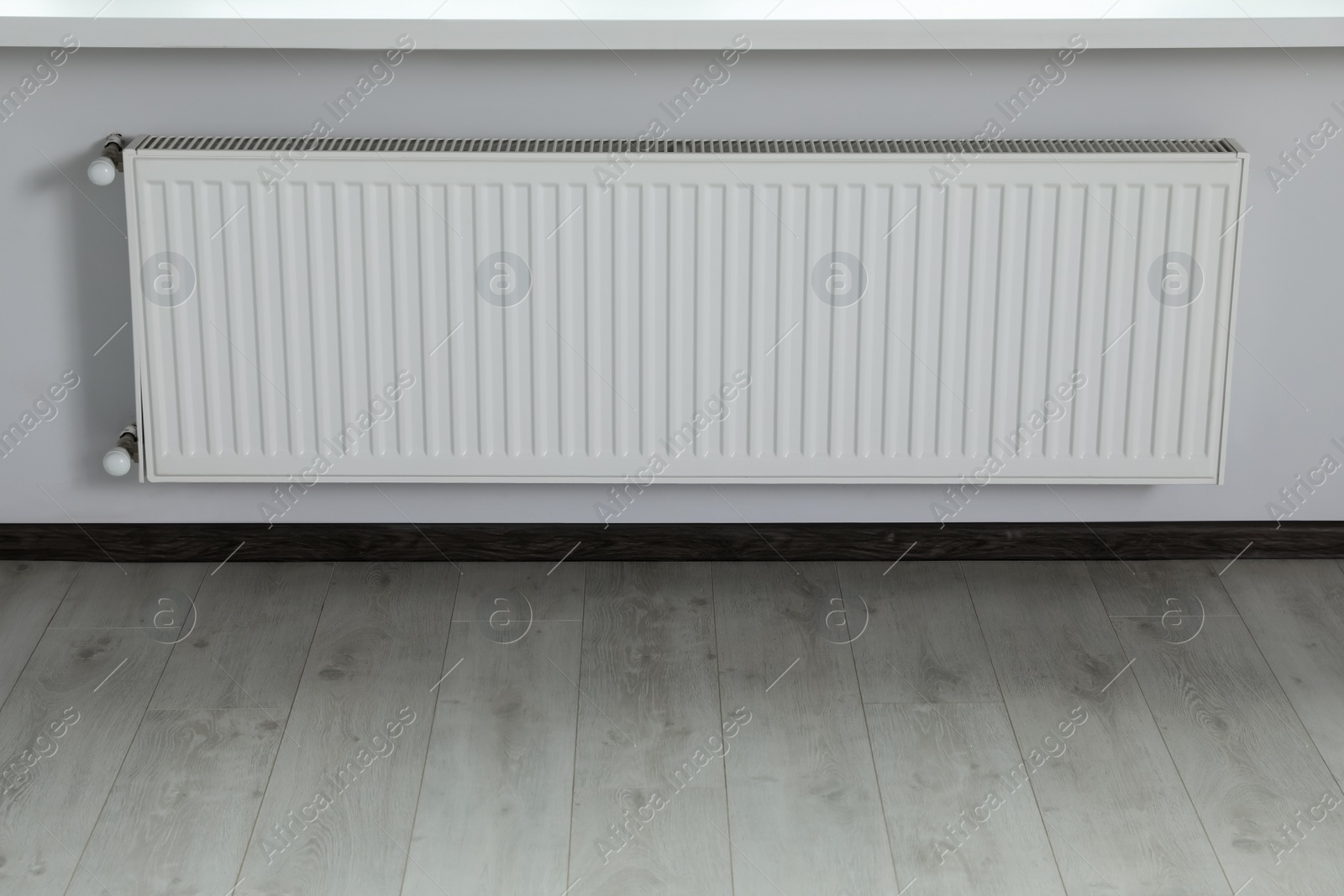 Photo of Modern radiator on white wall in office. Interior design