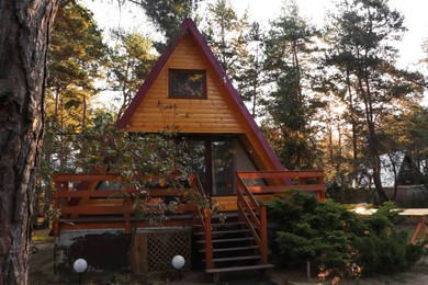 Photo of Picturesque view of modern wooden house with veranda near forest on sunny day