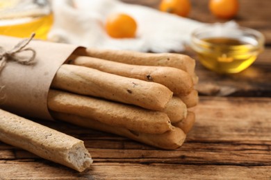 Photo of Delicious grissini sticks on wooden table, closeup