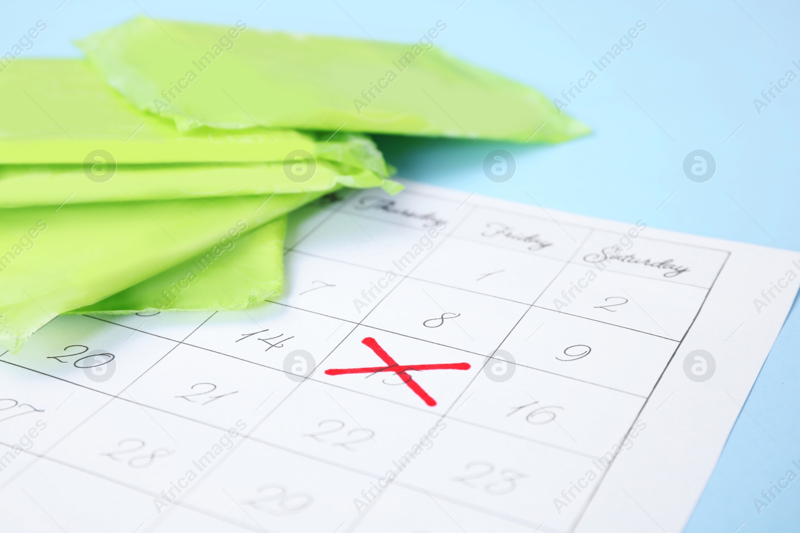 Photo of Calendar and menstrual pads on color background, closeup with space for text. Gynecological care