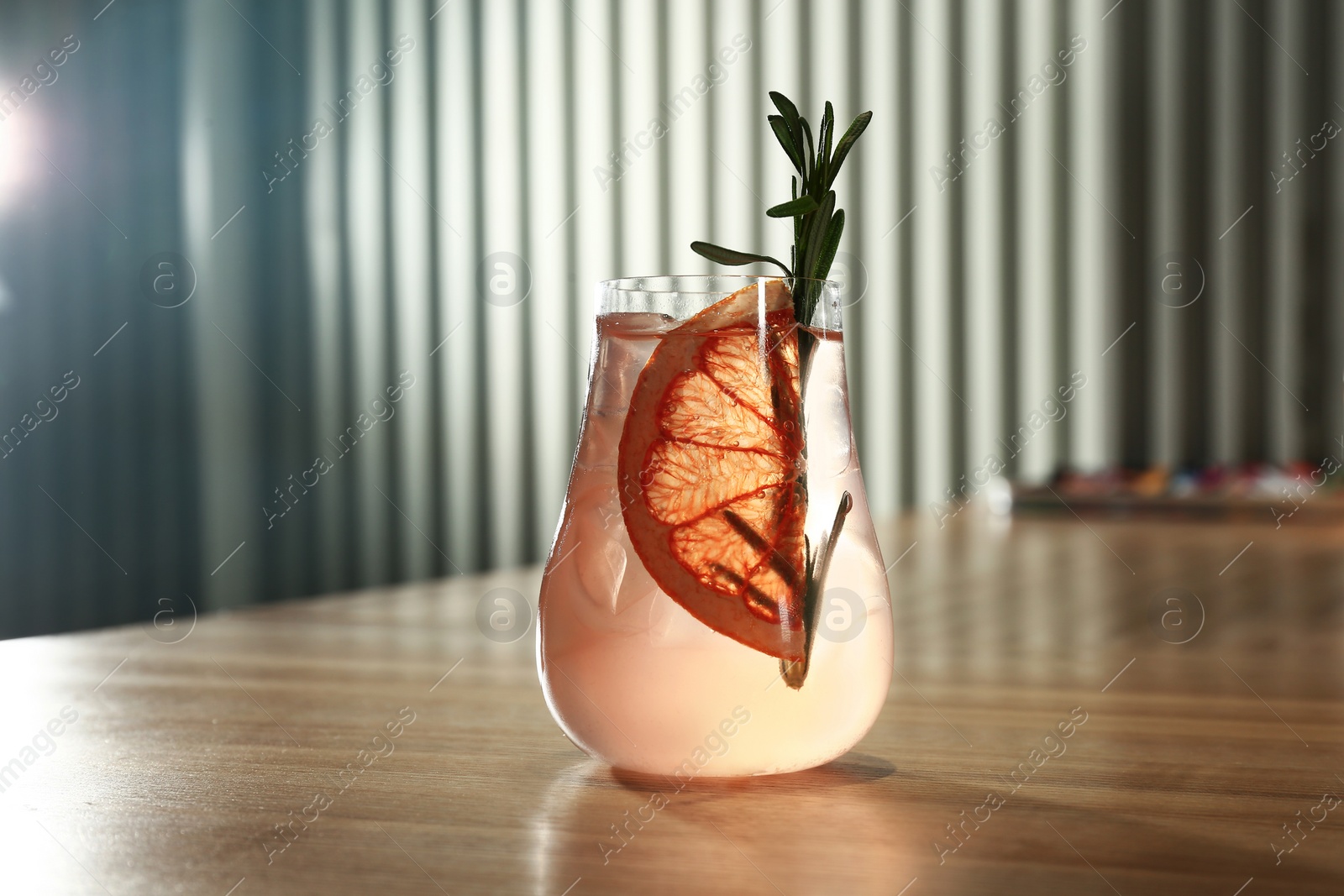 Photo of Glass of delicious cocktail with vodka on wooden counter in bar