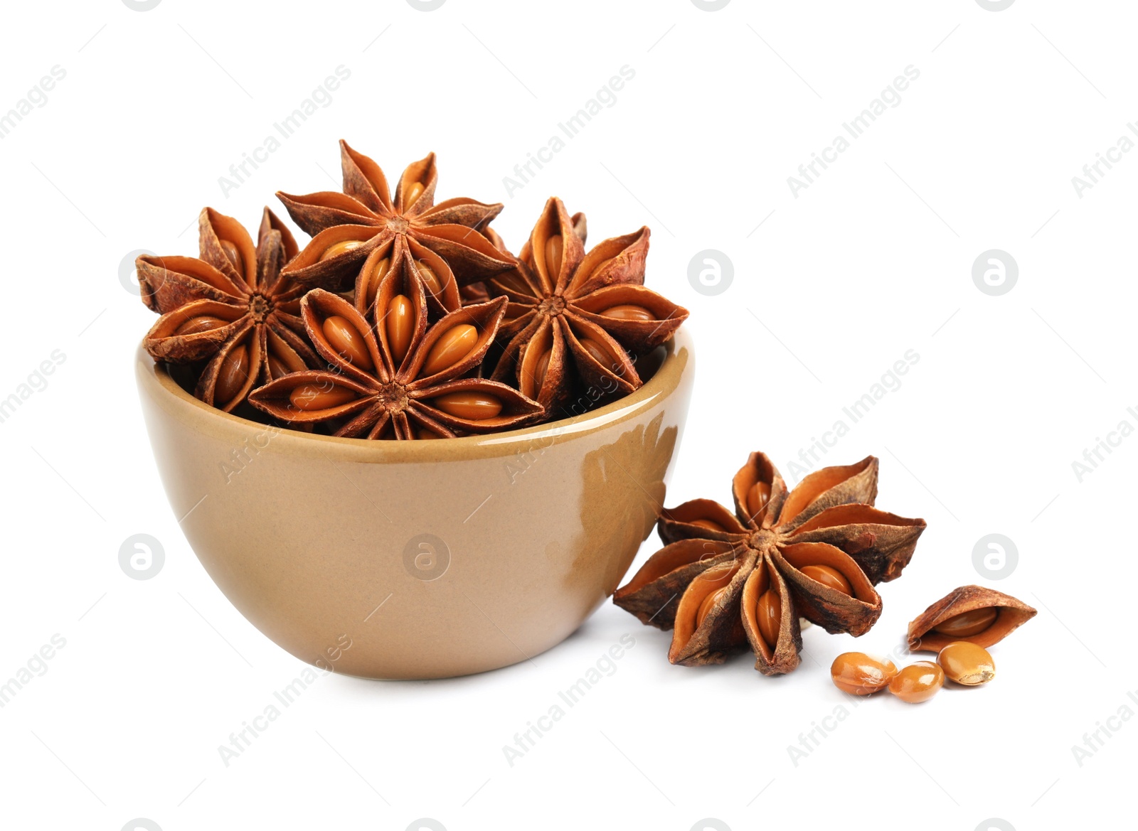 Photo of Bowl and dry anise stars on white background