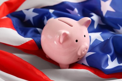 Photo of Pink piggy bank on national American flag, closeup