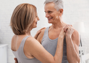 Photo of Happy senior couple dancing together at home