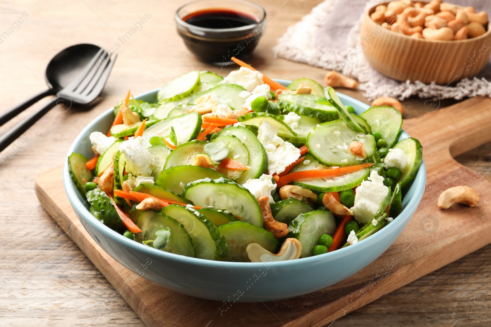 Photo of Delicious cucumber salad on wooden table, closeup