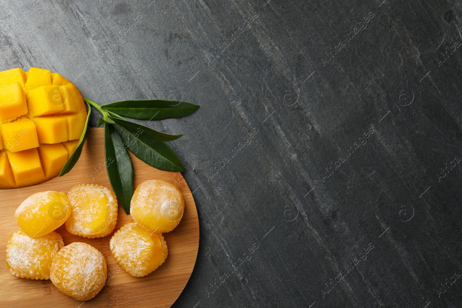Photo of Delicious mango mochi on grey table, flat lay. Space for text