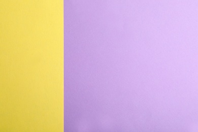 Photo of Violet and yellow paper sheets as colorful background, top view