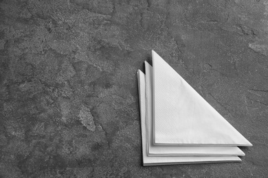 Photo of Clean napkins on grey background, top view with space for text. Personal hygiene