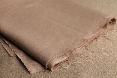 Photo of One folded light brown fabric on cloth, closeup