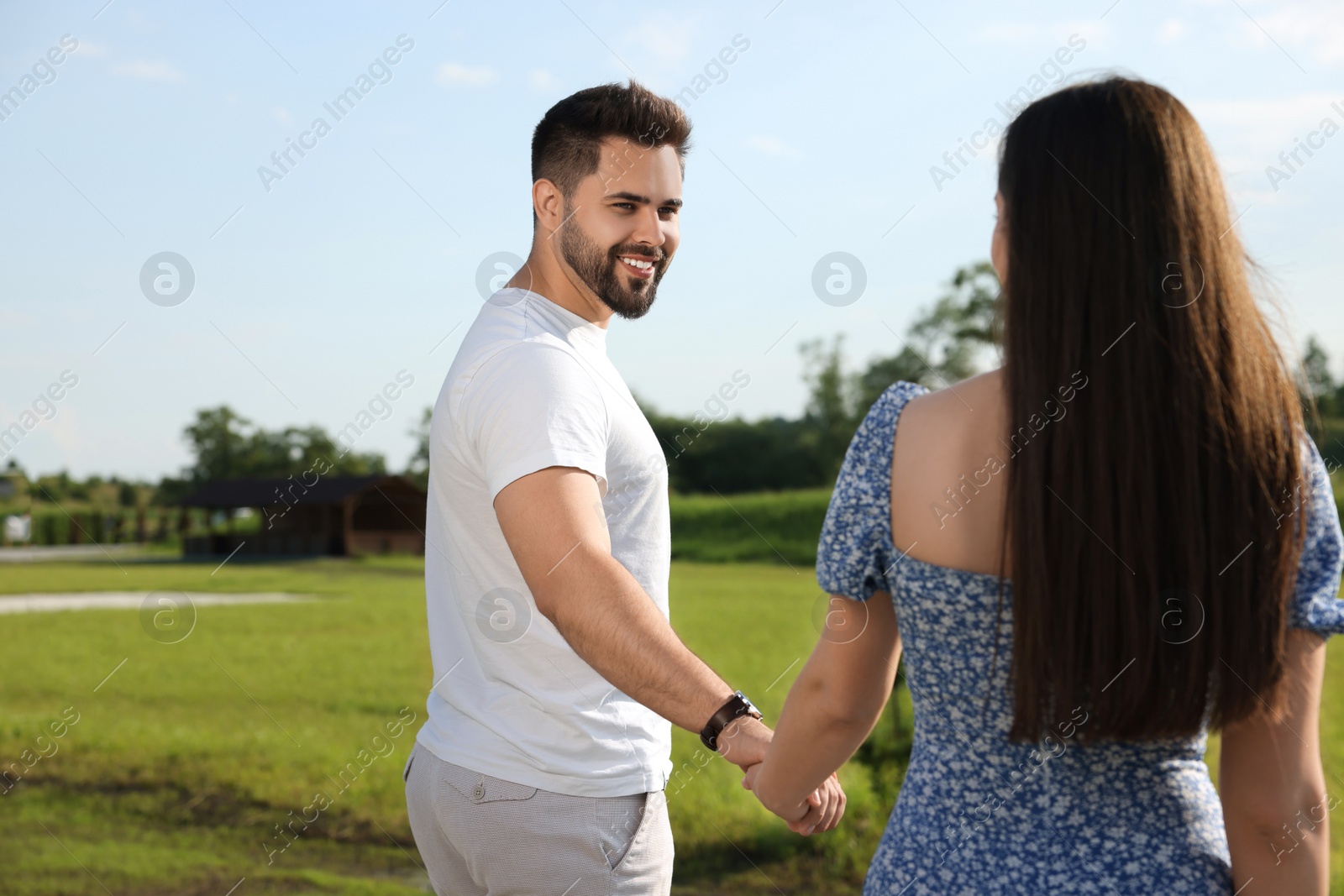 Photo of Romantic date. Beautiful couple walking outdoors on sunny day